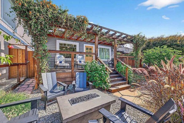 A patio with outdoor seating, a fire pit, and a pergola.