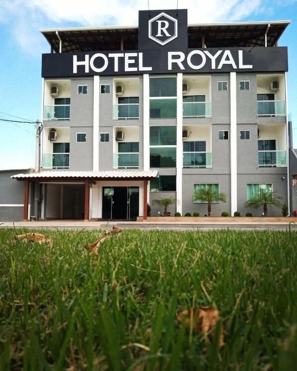 Un edificio a più piani con un cartello che indica “HOTEL ROYAL”.