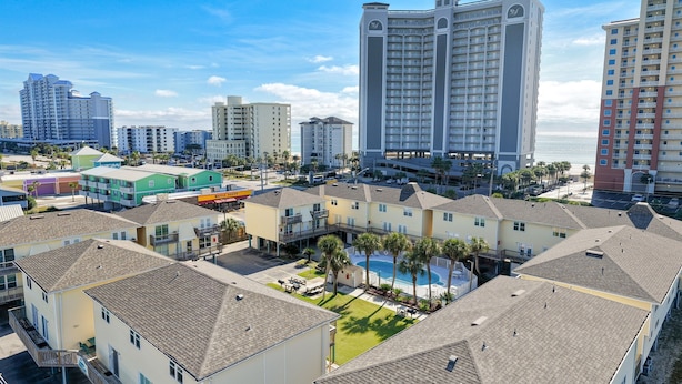 A coastal hotel complex with multiple buildings, a swimming pool, and a beach view. - Sand Dollar 5 – Your Bright & Breezy East Beach Getaway!  Free Daily Activities! (Gulf Shores)