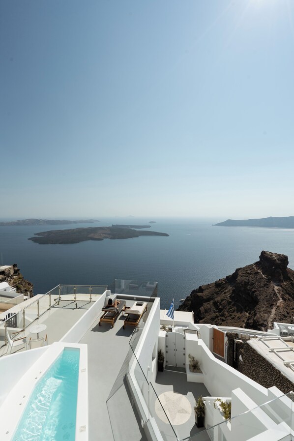A rooftop pool with a view of the sea and islands.