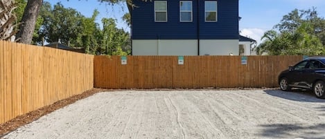 A two-story building with a blue exterior and a fenced backyard.