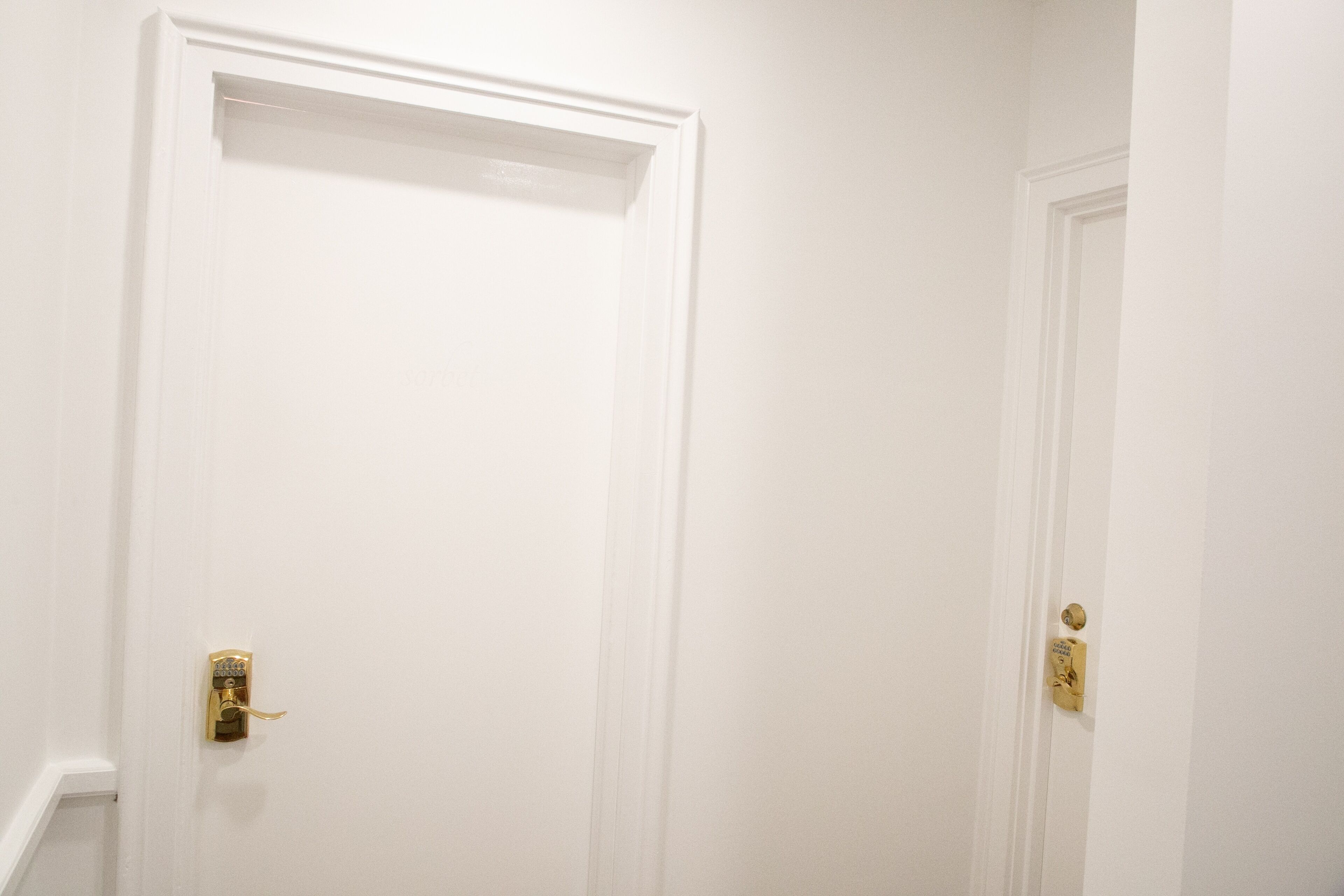 A white door with a brass handle and a keyhole.
