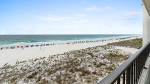 A beach view from a balcony with a clear sky, a sandy beach, and a boardwalk. - Surf Dweller 508 - Beachfront Boho (Fort Walton Beach)