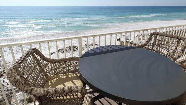 A balcony with wicker furniture overlooking a beach. - Sea Dunes 402 - Sunny Dolphin (Fort Walton Beach)
