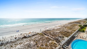 Une vue sur la plage, avec une piscine et une terrasse en bois.