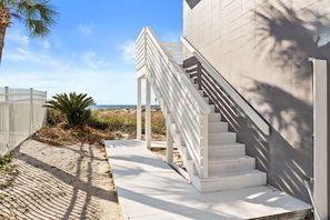 Una escalera blanca que lleva a un edificio con vista al mar.