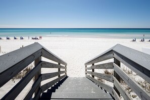 A wooden staircase leading to a beach with clear blue water and white sand. - Coconut Beach House A (Fort Walton Beach)