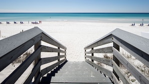 A wooden staircase leading to a beach with clear blue water and white sand. - Coconut Beach House A (Fort Walton Beach)
