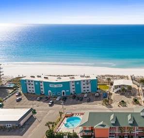 Un hotel con piscina, vistas a la playa y aparcamiento.