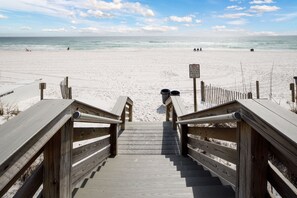 A wooden staircase leading to a sandy beach with a clear sky. - Bella Riva 108 - Golden Horizon (Fort Walton Beach)