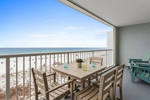 A balcony with a table and chairs overlooking a beach. - Islander 5006 - Ocean Star (Fort Walton Beach)
