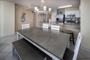 A modern kitchen with a central island, white cabinetry, and a chandelier. - Island Princess 701 - Beach Bum Bliss (Fort Walton Beach)