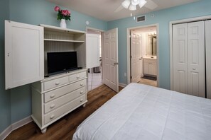 A bedroom with a bed, a dresser, a TV, and a closet. - Island Princess 701 - Beach Bum Bliss (Fort Walton Beach)