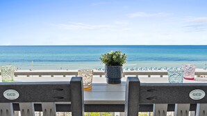 Une vue sur la plage avec une balustrade, une plante en pot et des objets de décoration en verre.