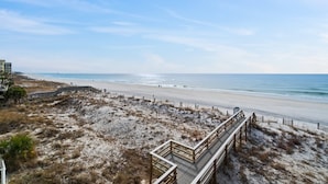 A beach with a wooden boardwalk leading to the shore, sandy dunes, and a clear blue sky. - Gulfside 401 - Sunny Side Up (Fort Walton Beach)