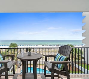 A balcony with a view of the ocean, a pool, and beach umbrellas. - Dune Pointe 402 - Shells, Surf & Sea Turtles (Fort Walton Beach)