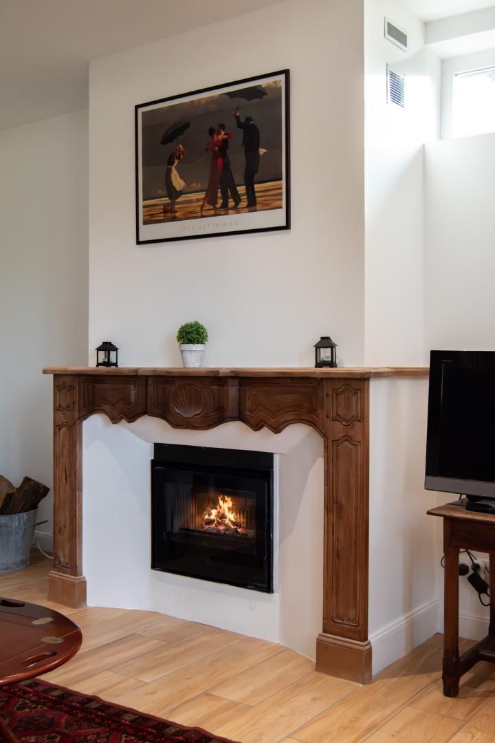Un salon avec une cheminée, un téléviseur et un tableau encadré accroché au mur.