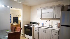 A modern kitchen with a central island, a built-in oven, a sink, and upper cabinets. - Cozy 3BR + Parking, Near Airport — Solar Backup! (Carolina)