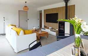 Un salon moderne avec un canapé, une table basse et un téléviseur fixé au mur.