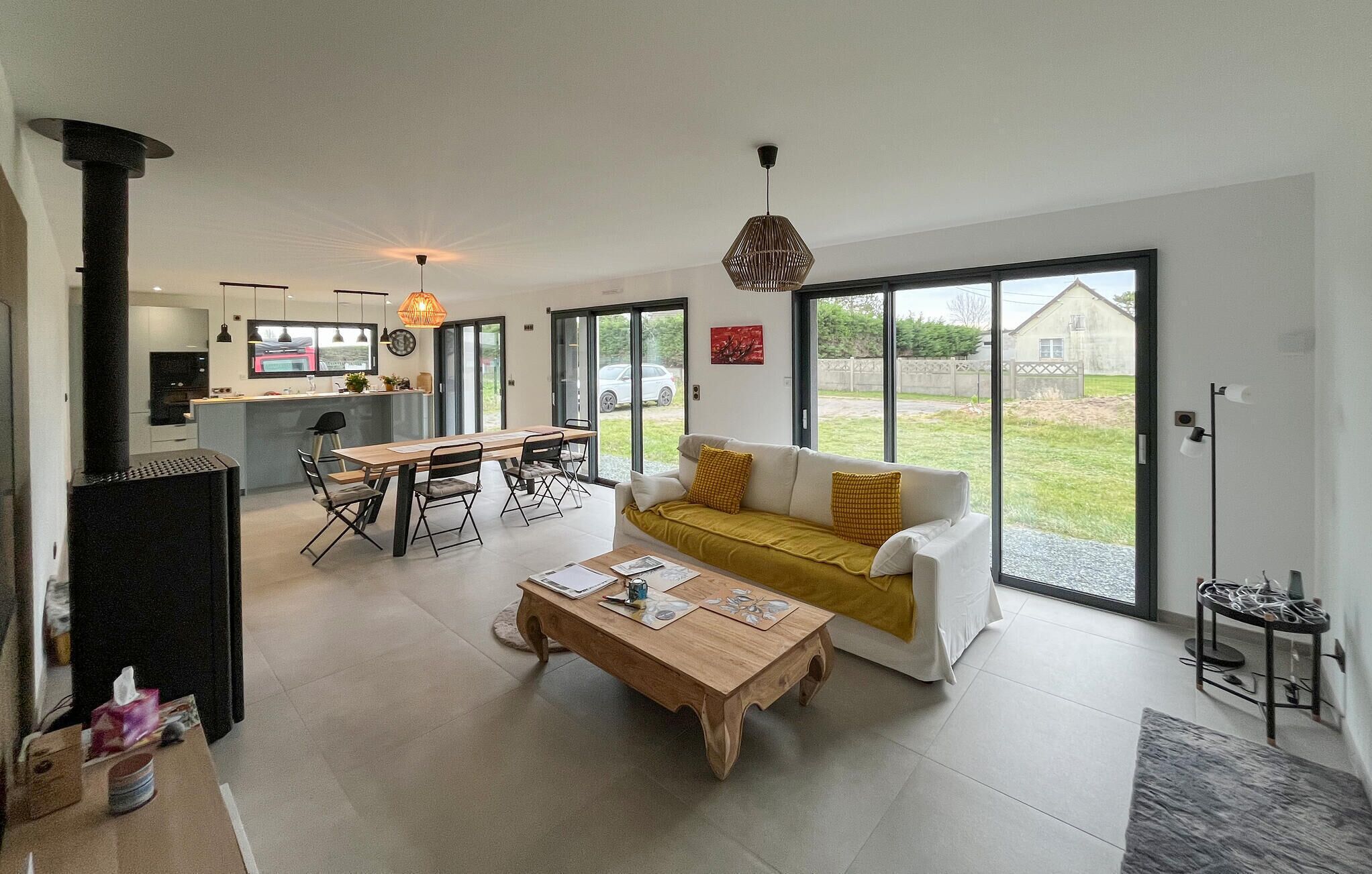 A modern living space with a kitchen, dining area, and a sofa with a view.