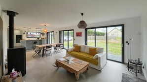 Un espacio habitable moderno con cocina, comedor y sofá con vistas.
