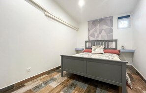 A bedroom with a bed, a nightstand, a wall-mounted shelf, a geometric-patterned wall, and a window. - 3 bedroom stunning home in Miramas (Miramas)