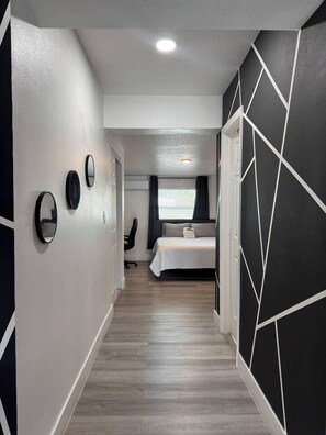 A hotel corridor with a bed, a chair, and a desk. - Casita Noir by Tampa Bay Hotspots & Airport! (Tampa)