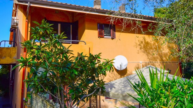A two-story house with a satellite dish, a small window with shutters, and a balcony with a metal railing. - Gorgeous apartment in Drapia with swimming pool (Drapia)