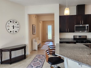 A modern kitchen with dark cabinets, stainless steel appliances, and a granite countertop. - Great location in St John's County (St Johns)