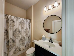 A bathroom with a toilet, sink, mirror, and shower curtain. - Great location in St John's County (St Johns)