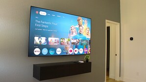 Een flatscreen televisie aan een muur met een streamingdienst interface en diverse app-icoontjes.