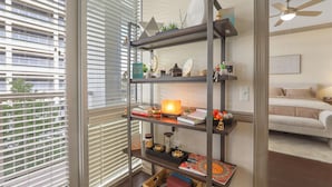 Ein Zimmer mit Bücherregal, Bett und Deckenventilator.