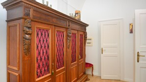 Ein hölzerner Kleiderschrank mit aufwendigen Schnitzereien und einer Tür aus rot gemustertem Glas.