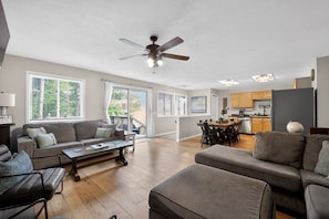 A spacious living area with a sofa, coffee table, and a ceiling fan. - Torch + Timber House (Rapid City)