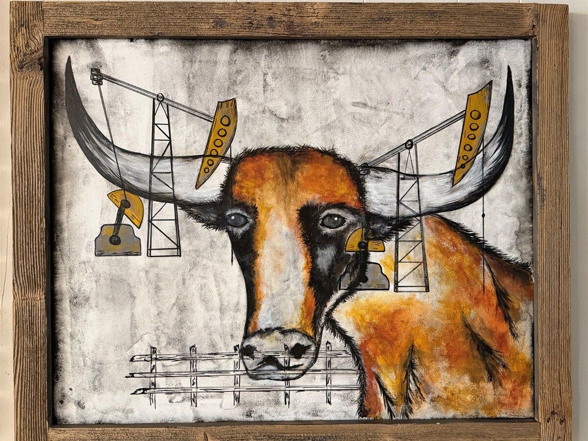 A framed artwork of a bull with horns and bells.