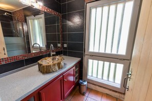A bathroom with a wooden sink, red cabinets, a mirror, and a shower area. - Le Pignot - GREEN - Gîte (VERT)