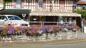 En toetagers bygning med et skilt, der viser 'Tabac Souvenirs Cadeaux Tabac'.