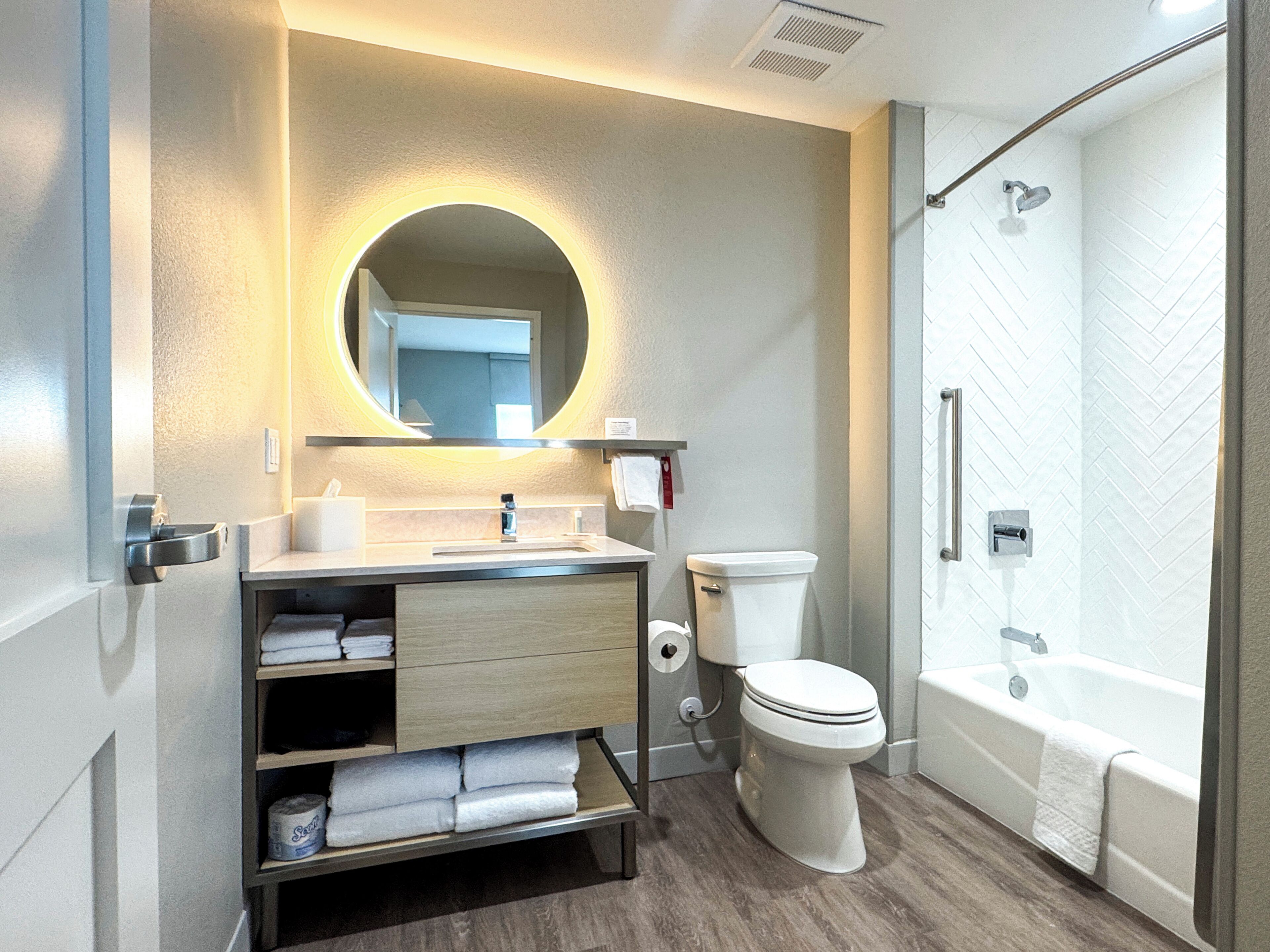 A modern bathroom with a sink, toilet, and shower.