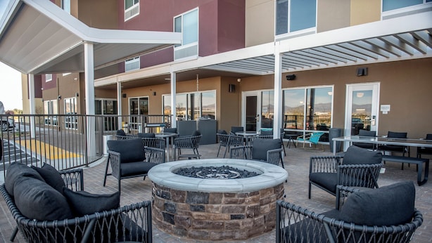 An outdoor patio with a fire pit, wicker chairs, and tables. - Towneplace Suites By Marriott Ridgecrest (Ridgecrest)