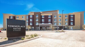 Un hôtel à plusieurs étages, avec une enseigne indiquant « Towneplace Suites by Marriott » à l’avant.