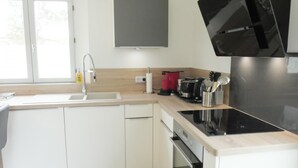 Cozinha moderna com pia, fogão e eletrodomésticos embutidos.