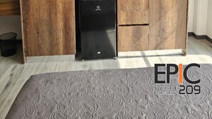 A compact kitchen with wooden cabinetry, a built-in microwave, and a coffee machine. - Epic Suite 209 Deluxe Aeropuerto (Pereira)
