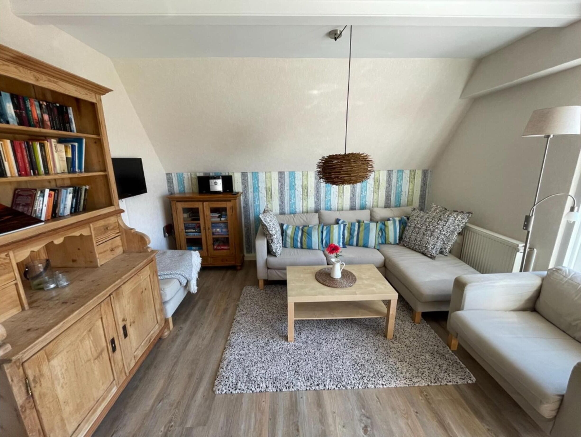 A living room with a sofa, a coffee table, a bookshelf, and a cabinet.