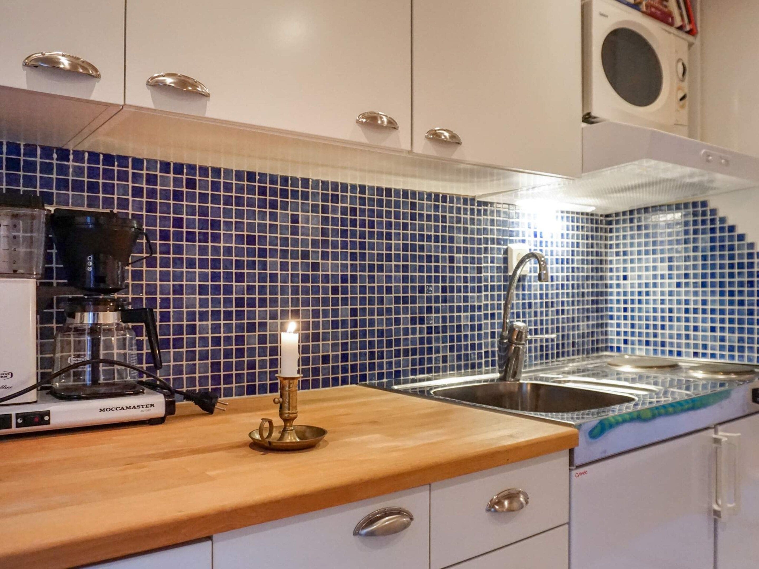 A kitchen with a coffee maker, a candle, and a sink.