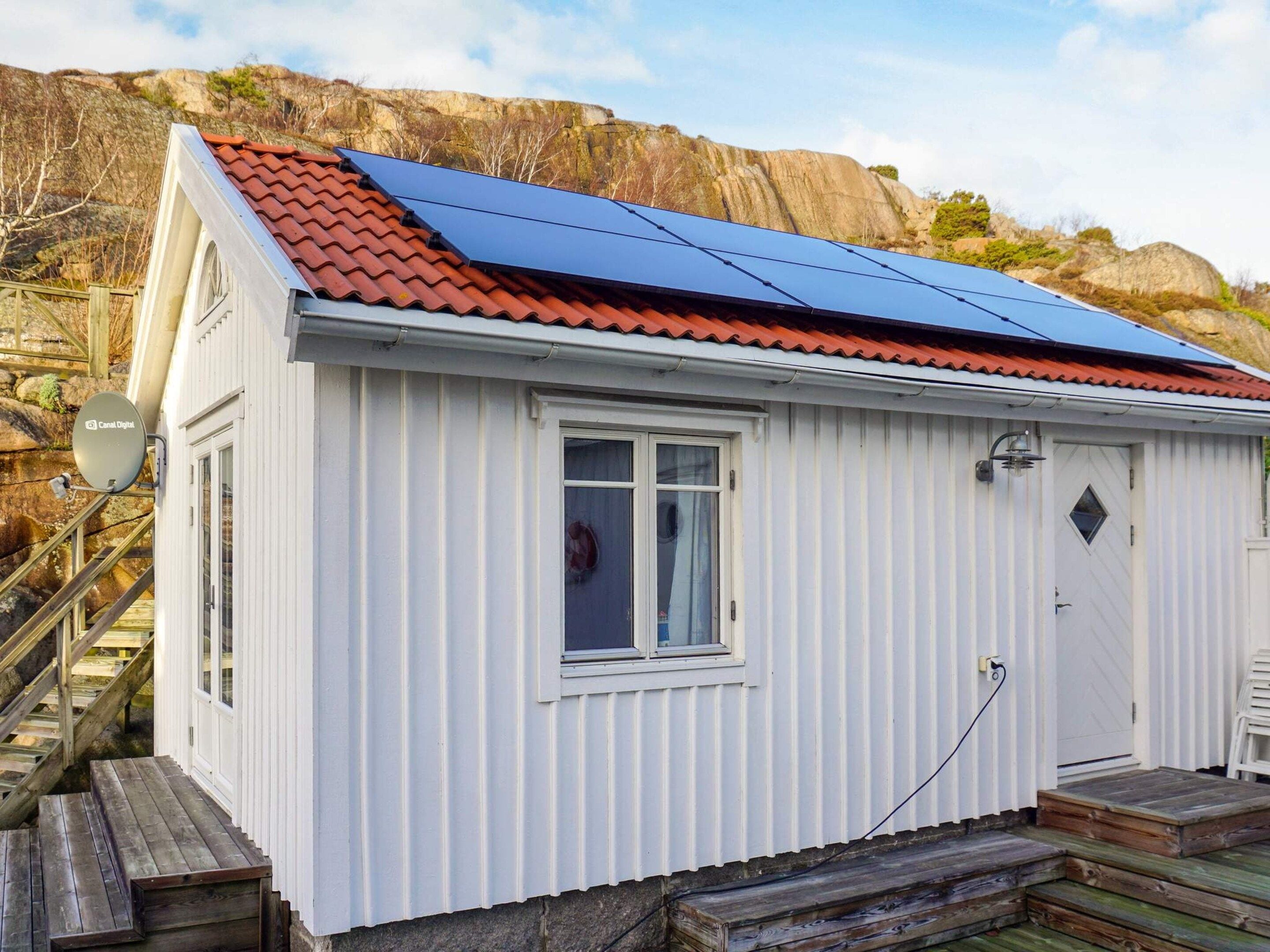 Un bâtiment blanc avec un toit rouge, une fenêtre et une porte.