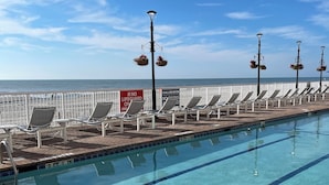 Une piscine avec des chaises longues et vue sur l’océan.