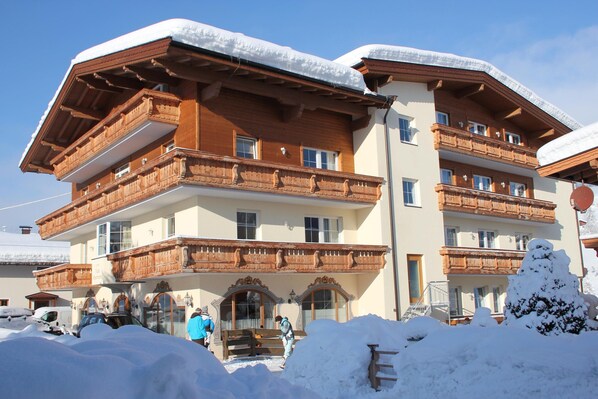 A multi-story building with wooden balconies and a snow-covered roof. - Vicky Apartment With Infrared Cabin (Wildschönau)