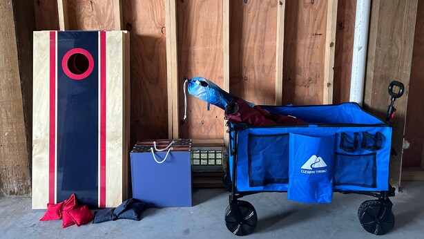Ein Zimmer mit Holzwänden, einem blauen Rollwagen, einer blauen Tasche und einer roten und schwarzen Kiste.