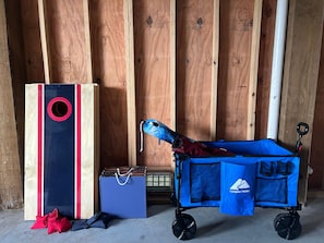 A room with wooden walls, a blue storage cart, a blue bag, and a red and black box. - Oyster and Pearl (Galveston)