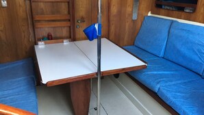 Una stanza piccola con un tavolo di legno e un divano blu.